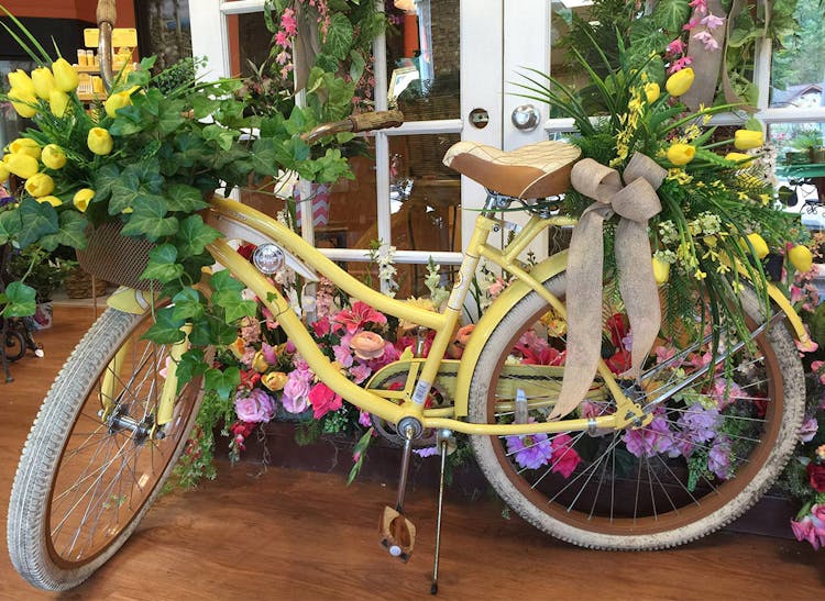 A bicycle decorated with fresh yellow flowers; an accent at our Mobile, Alabama location
